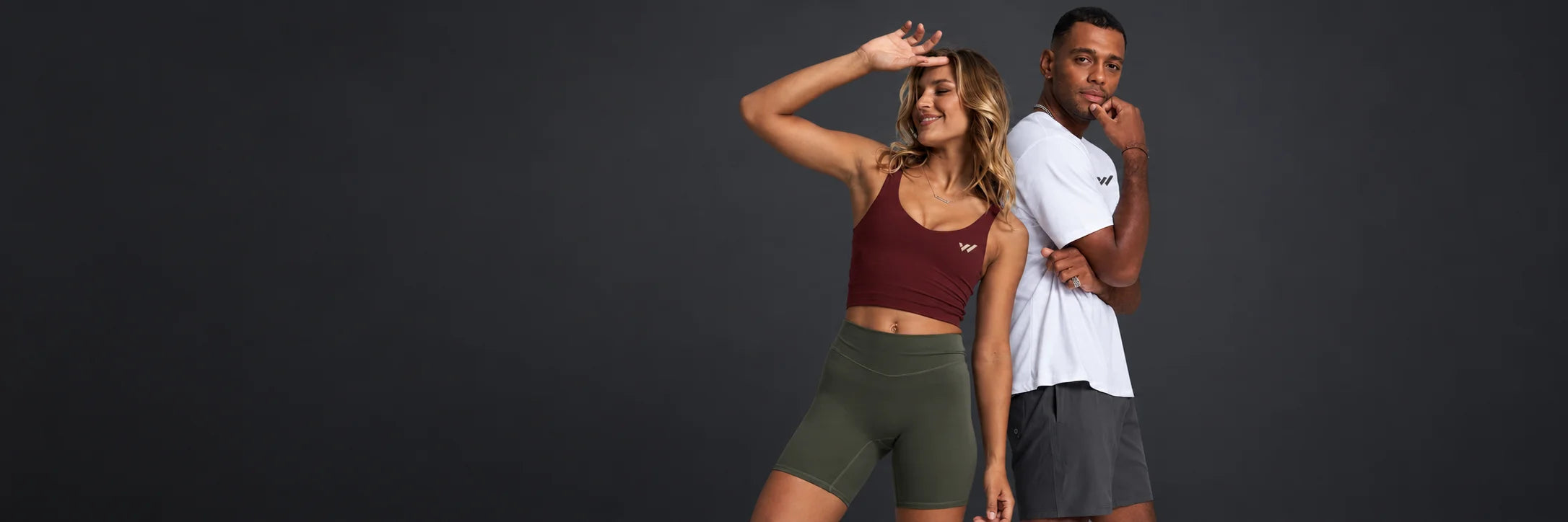 Two athletes wearing Willpower apparel in a charcoal studio